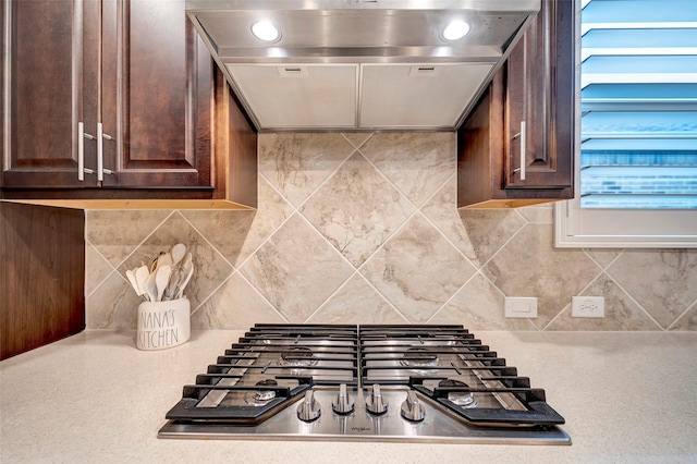 kitchen featuring decorative backsplash, dark brown cabinets, extractor fan, and stainless steel gas cooktop