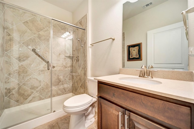 bathroom featuring tile patterned flooring, vanity, toilet, and an enclosed shower