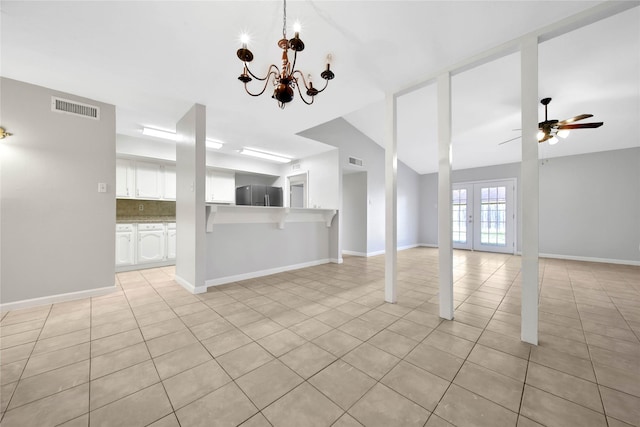 unfurnished living room featuring light tile patterned floors, ceiling fan with notable chandelier, and vaulted ceiling