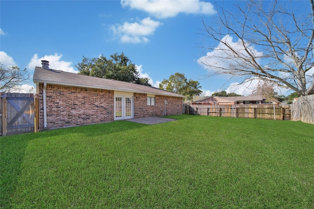 back of house with french doors and a yard