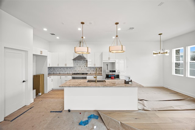 kitchen with white cabinetry, hanging light fixtures, visible vents, and a sink