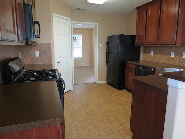 kitchen with backsplash, sink, light tile patterned floors, and black appliances