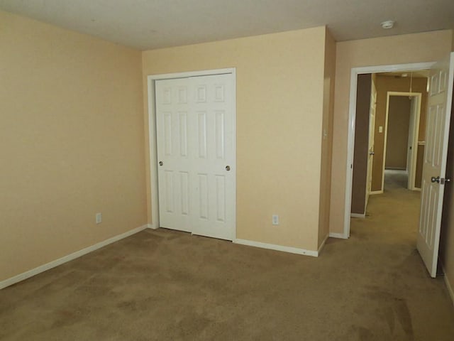 unfurnished bedroom with light carpet and a closet