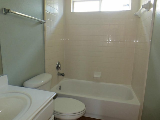 full bathroom with vanity, tiled shower / bath, a healthy amount of sunlight, and toilet