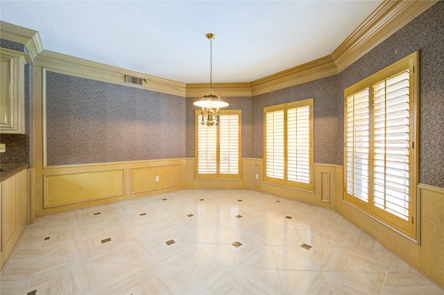 unfurnished dining area with ornamental molding and a notable chandelier