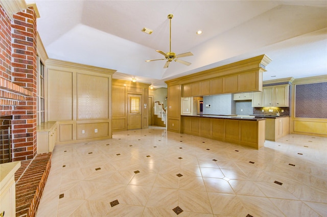 kitchen featuring backsplash, ceiling fan, a tray ceiling, and lofted ceiling