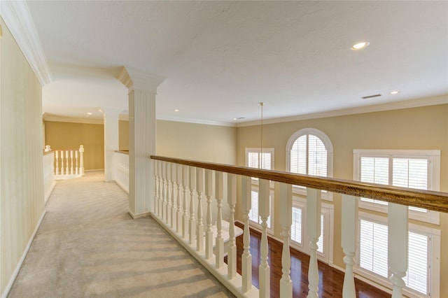 hall with crown molding and light carpet