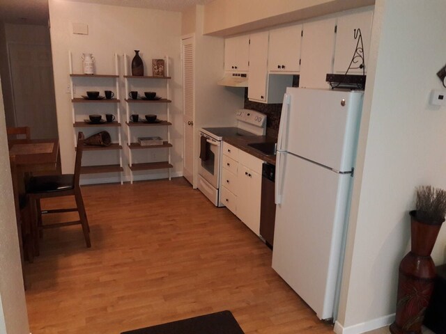 kitchen featuring light wood-type flooring, backsplash, white appliances, sink, and white cabinets