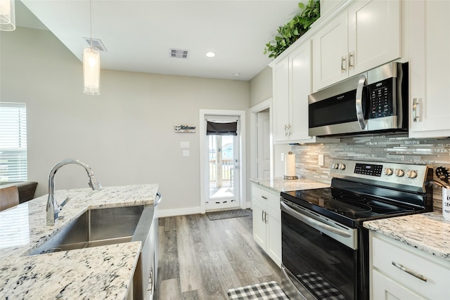 kitchen with white cabinets, pendant lighting, sink, and appliances with stainless steel finishes