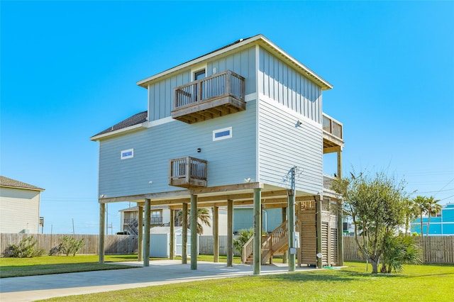 rear view of property with a yard and a balcony