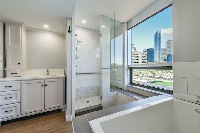 bathroom featuring vanity, hardwood / wood-style flooring, and separate shower and tub