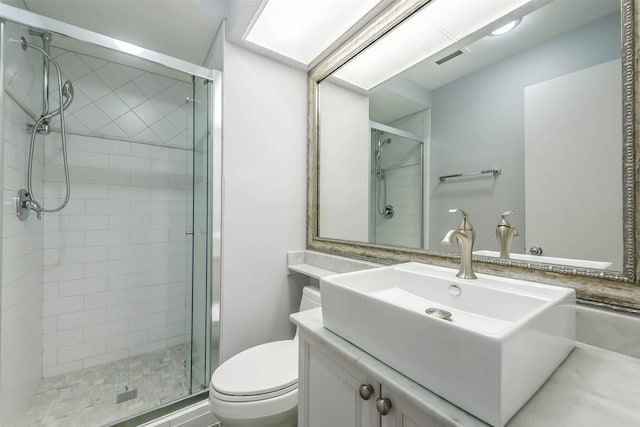 bathroom featuring vanity, toilet, and a shower with shower door