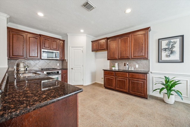 kitchen featuring sink, stainless steel appliances, backsplash, crown molding, and dark stone counters