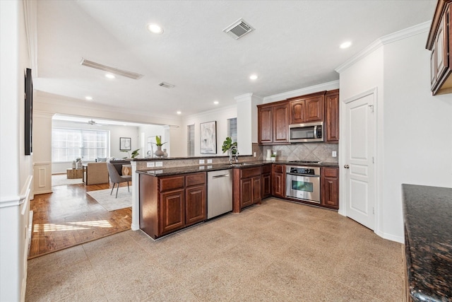 kitchen featuring sink, ceiling fan, tasteful backsplash, kitchen peninsula, and stainless steel appliances