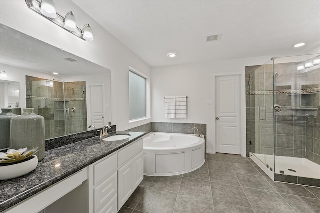 bathroom with plus walk in shower, vanity, and tile patterned flooring