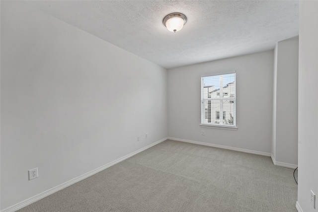 carpeted spare room featuring a textured ceiling