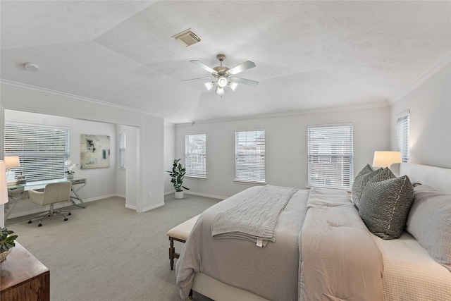 carpeted bedroom with a tray ceiling, multiple windows, ceiling fan, and crown molding