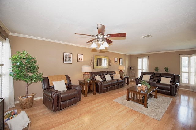 living room with crown molding, plenty of natural light, and light hardwood / wood-style flooring