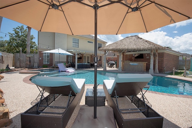 view of pool with a bar, a gazebo, a patio, and an in ground hot tub