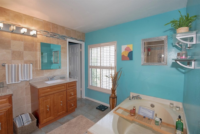 bathroom with vanity, tile patterned flooring, a tub, and tile walls