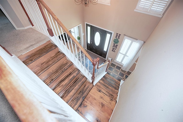 entrance foyer featuring a high ceiling, hardwood / wood-style floors, and a chandelier