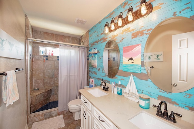 bathroom featuring vanity, tiled shower, and toilet