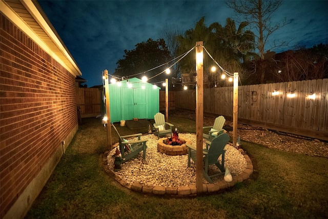 yard at twilight featuring a storage shed and a fire pit