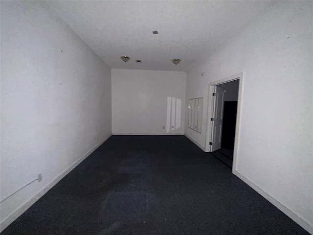 7555 Morley St, Houston, TX 77061 - empty room with a textured ceiling, dark colored carpet, and baseboards
