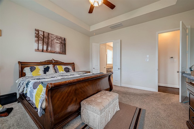 bedroom with a raised ceiling, ceiling fan, and carpet floors