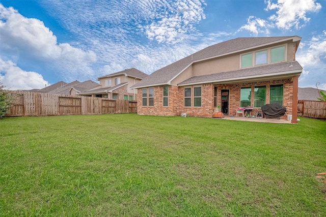 back of property with a yard and a patio