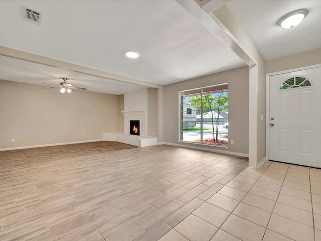 unfurnished living room with ceiling fan