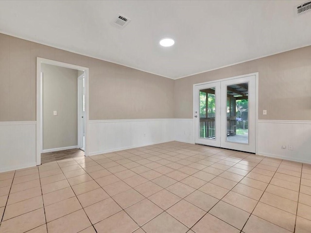 empty room with french doors and light tile patterned flooring