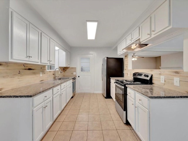 kitchen with white cabinets, stainless steel appliances, and dark stone counters