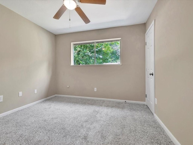 carpeted spare room featuring ceiling fan