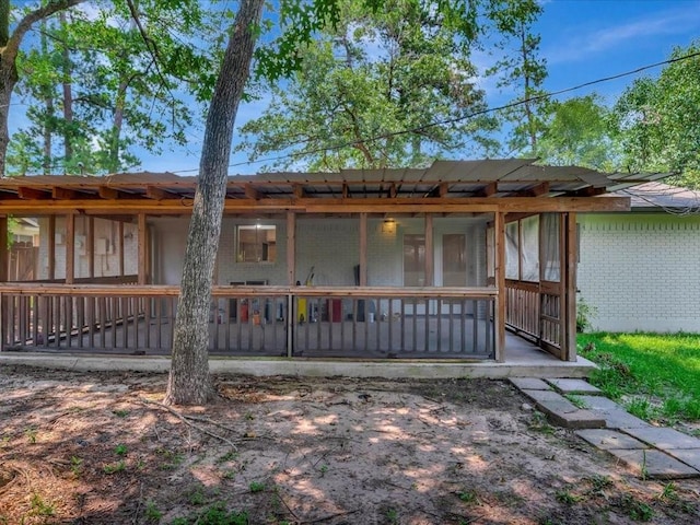 rear view of property featuring a sunroom