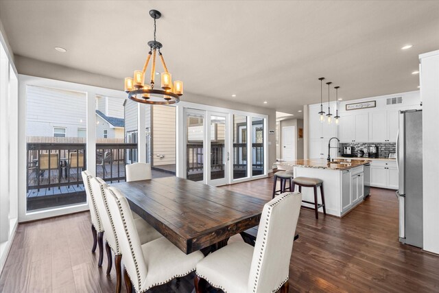 dining room with a chandelier, dark wood-type flooring, and sink