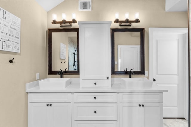 bathroom with vanity and lofted ceiling