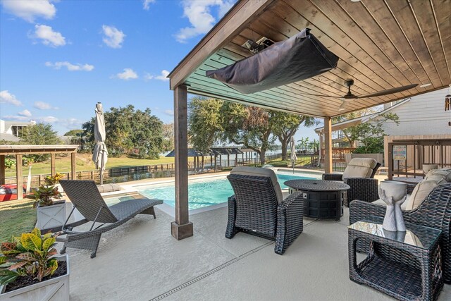 view of patio with ceiling fan and a fenced in pool