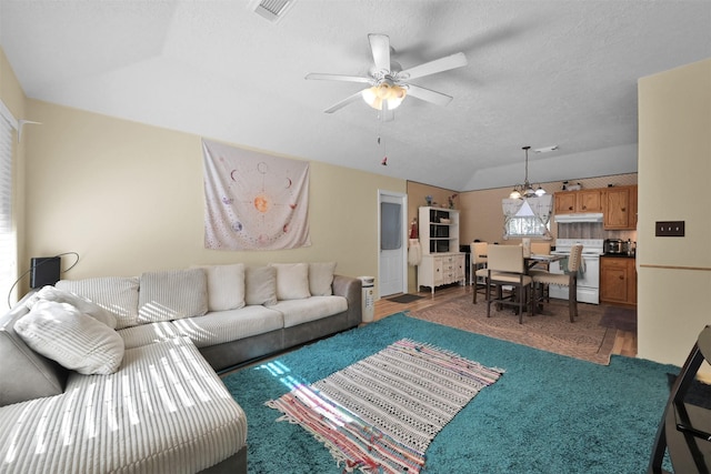 living room with a textured ceiling, ceiling fan with notable chandelier, and lofted ceiling