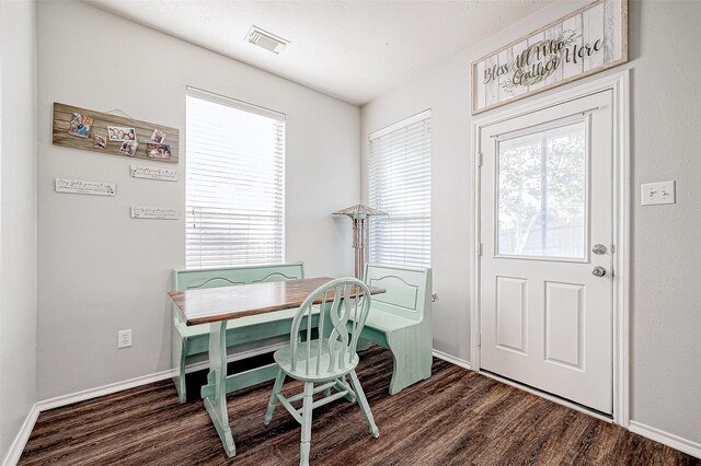 dining area with dark wood-type flooring and a wealth of natural light