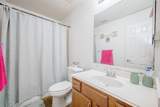 bathroom with vanity, toilet, and a textured ceiling