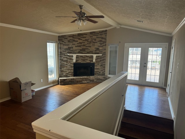 unfurnished living room with dark wood-type flooring, french doors, lofted ceiling with beams, and a textured ceiling