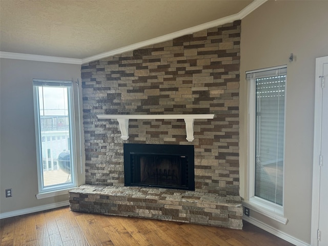 room details with crown molding, a large fireplace, a textured ceiling, and hardwood / wood-style flooring