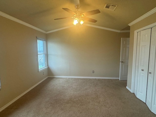 unfurnished bedroom with ornamental molding, ceiling fan, carpet floors, a closet, and lofted ceiling