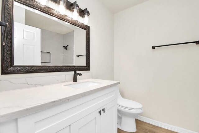 bathroom with hardwood / wood-style floors, vanity, and toilet