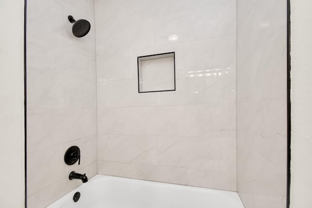 bathroom featuring tiled shower / bath