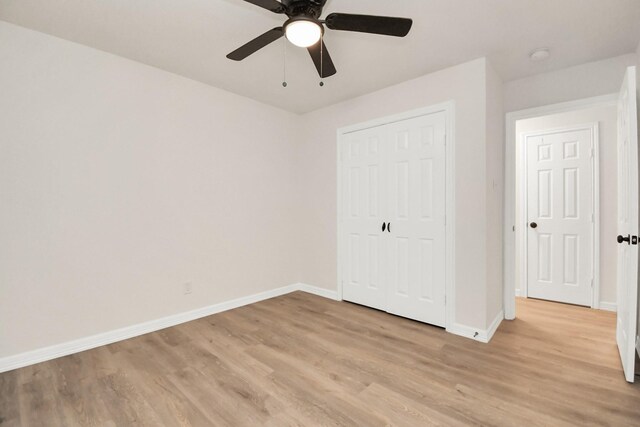 unfurnished bedroom with ceiling fan, a closet, and light wood-type flooring