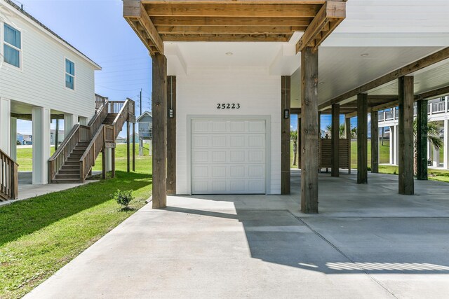 garage featuring a carport and a lawn