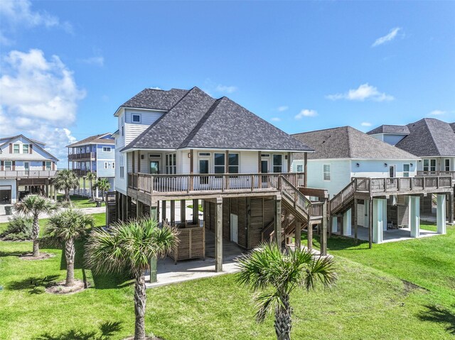 back of house featuring a carport, a wooden deck, and a lawn