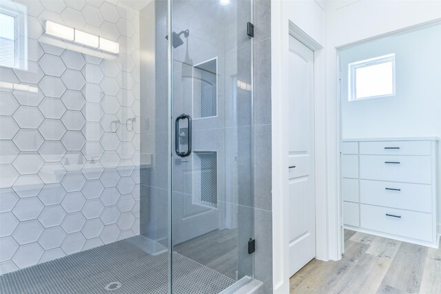 bathroom featuring hardwood / wood-style floors and a shower with shower door